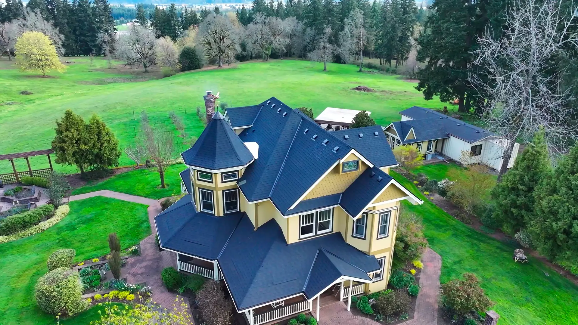 Aerial view of a Victorian home with a new dark asphalt shingle roof by Dexica Construction in the Oregon Pacific Northwest